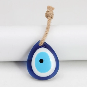 Macro detail of teardrop blue glass evil eye pendant with natural hemp rope cord