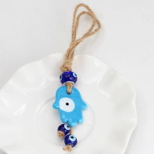 Detail showing handcrafted blue Hamsa evil eye glass pendant with rustic hemp rope hanger