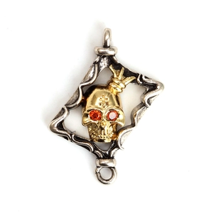 Colgante calavera gótica dorada con corona y gemas en marco plateado de rombo