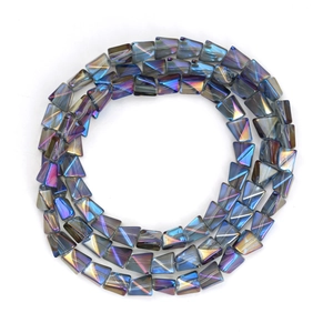 Macro shot of iridescent trapezoid glass beads with deep blue and purple aurora finish