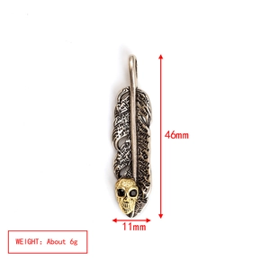 Detalle del colgante de pluma gótica en plata vieja con calavera dorada y medidas