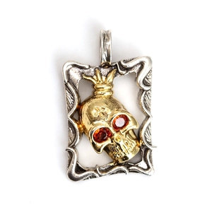 Colgante calavera gótica con ojos de gema roja y grabado de cruz en marco retro
