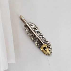 Colgante de pluma de plata con calavera dorada y cristales negros de estilo gótico