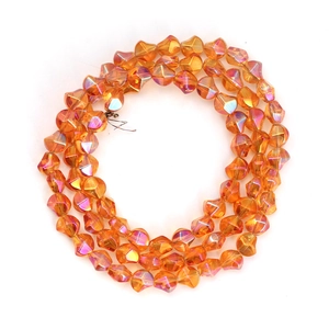Detailed macro view of irregular translucent orange glass beads with iridescent AB coating