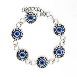 Detalle de pulsera de aleación plateada con dijes de ojo turco azul y cierre de langosta