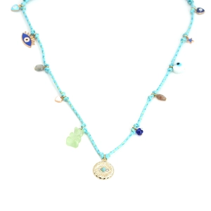 Detail of blue woven necklace featuring evil eye charms and a green gummy bear pendant