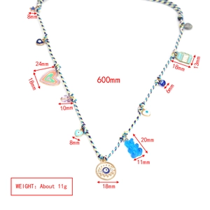 Detailed view of colorful woven necklace with bear and evil eye charms showing 600mm length