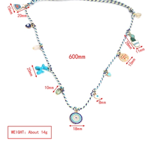 Detailed view of colorful woven necklace with lucky eye and balloon dog charms