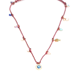 Detail of colorful woven necklace featuring evil eye, cactus, and rainbow charms