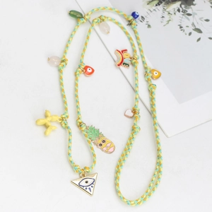 Close-up of woven cord necklace with rainbow LOVE charm and yellow balloon dog pendant