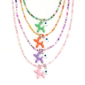 Détail de colliers en perles colorées avec pendentifs chien ballon et œil porte-bonheur bleu