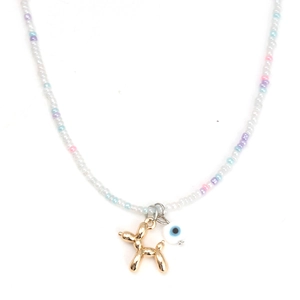 Détail du collier de perles avec un pendentif chien ballon doré et l'œil porte-bonheur