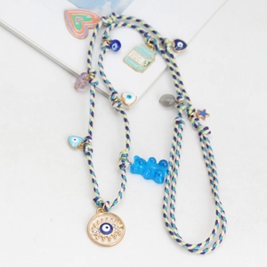 Colorful woven necklace with blue gummy bear and evil eye pendant charms