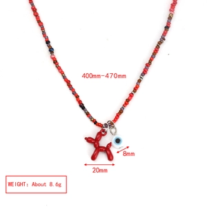 Détail du collier à perles rouges avec pendentifs chien ballon et œil maléfique