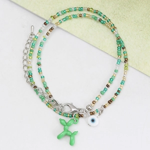 Détail du collier à double rang de perles avec chien ballon vert et pendentif mauvais œil