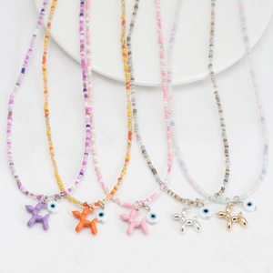 Détail de colliers en perles colorées avec pendentifs chien ballon et œil maléfique