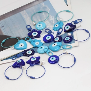 Detalle del set de llavero Evil Eye con amuletos de resina azul y mano de Fátima