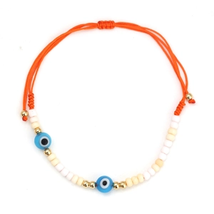 Close-up of handmade evil eye bracelet with orange woven cord and blue glass beads