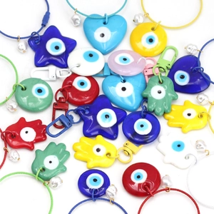 Vista detallada de dijes coloridos de ojo turco en formas de Hamsa y corazón