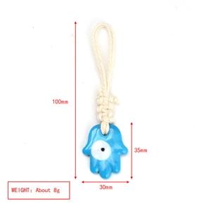Detailed view of handmade cotton rope Hamsa charm with blue glass evil eye pendant