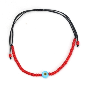 Detail of handmade red beaded evil eye bracelet with adjustable black cord closure