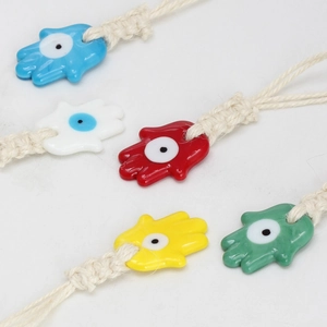 Detail of colorful Hamsa Hand charms with Evil Eye and handmade woven rope cords