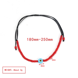 Detailed view of handmade red bead and blue evil eye bracelet with adjustable black rope