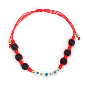 Detail of red braided evil eye bracelet with black volcanic rock beads and gold accents