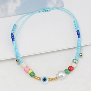 Handmade woven blue string bracelet with colorful beads and a protective evil eye charm