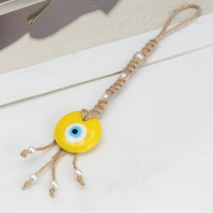 Handmade Evil Eye keychain with yellow bead, woven hemp rope, and elegant white pearls