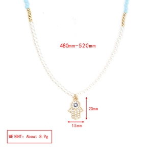 Detail of Hamsa Hand pendant with evil eye motif and colorful beaded strand necklace