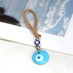 Detail of blue evil eye charm with braided hemp rope and metallic silver beads