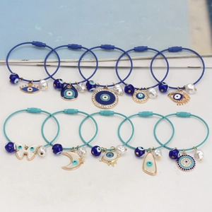 Detailansicht bunter Evil Eye Drahtarmbänder mit Emaille-Anhängern und Perlen
