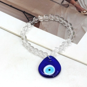 Detailed macro view of crystal beads bracelet with blue evil eye water drop charm