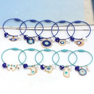 Detailansicht der Evil Eye Anhänger und Perlen auf bunten Drahtseilarmbändern mit Schraubverschluss