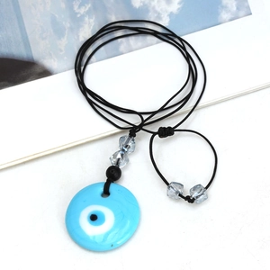 Detail van de blauwe boze oog nazar hanger aan zwart geweven verstelbaar koord