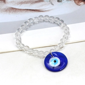 Close-up of glass beaded keychain with blue evil eye pendant on a white surface