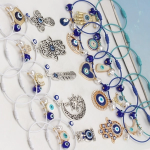 Makro-Detail diverser Nazar-Augen-Anhänger mit Hamsa-Hand Mond und Herzformen