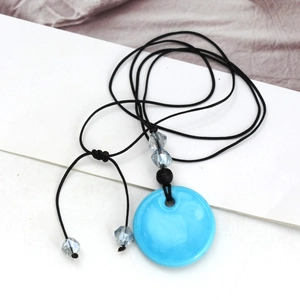Detail van de blauwe Evil Eye kristallen hanger met zwart koord en glazen kralen