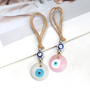 Macro detail of bohemian evil eye pendants featuring hemp rope and colorful resin beads