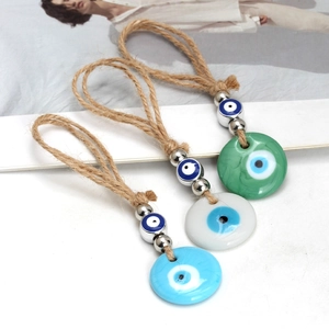 Detailed close-up of three Evil Eye pendants with blue and green glass beads on hemp rope