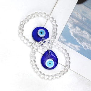 Detail of beaded evil eye bracelet with blue glass circular and teardrop charm pendants