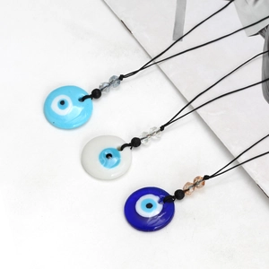 Detailopname van Evil Eye hangers in lichtblauw, opaalwit en marineblauw met zwart koordje