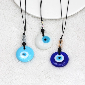 Detailweergave van de Evil Eye glazen hangers in blauw en wit aan zwarte koorden