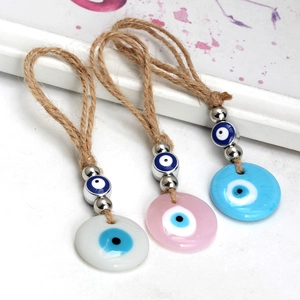 Three colorful evil eye charms with hemp rope and silver beads in blue, pink, and white