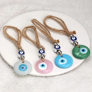 Close-up of four colorful Evil Eye hanging charms with rope loop and metallic beads