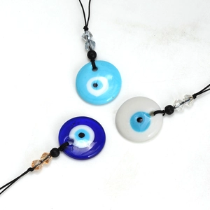 Gedetailleerd zicht op drie kleurrijke Evil Eye hangers met zwarte koorden en kralen