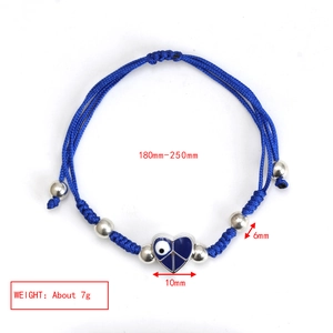 Detailed view of blue woven rope bracelet with heart evil eye charm and silver beads
