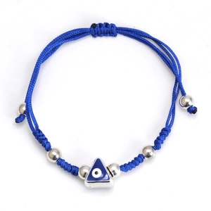 Detail of blue braided rope bracelet featuring a triangular Evil Eye charm and silver beads