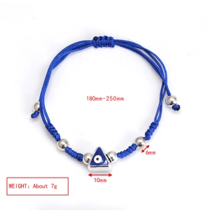 Macro detail of blue braided rope bracelet with triangle evil eye charm and silver beads